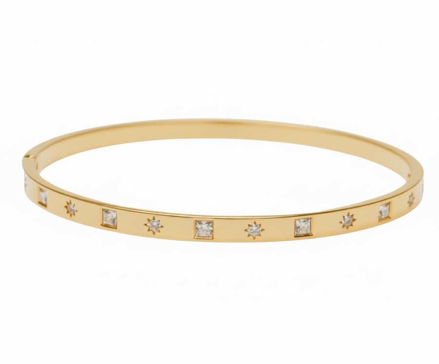 Gold bracelet with embedded diamonds on a white background